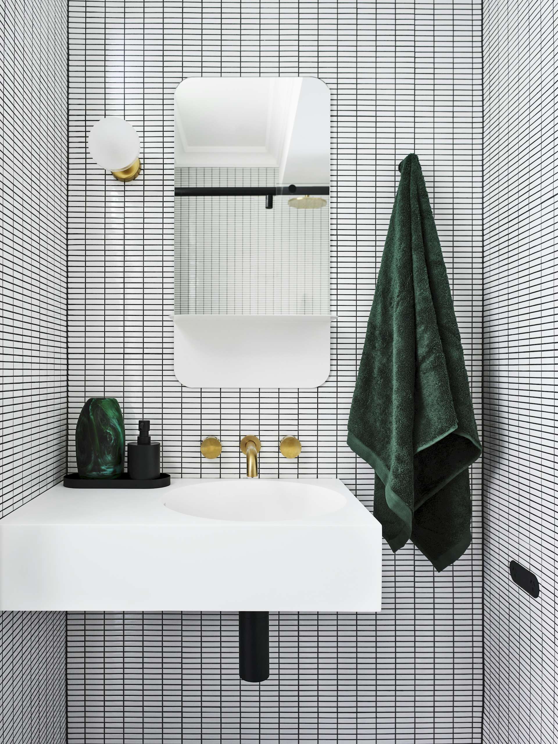 If Bradley had to choose a favorite bathroom design in her portfolio, it would be this guest bathroom. "Incorporating a strong, geometric pattern through the use ofwhite, rectangular mosaic tiles with black grout created the illusion of space," she says. 