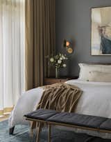 Workstead sconces and artwork by Zoe Bios Creative add more drama to the feature wall in the master bedroom, which is completed with a bench from Design Within Reach.&nbsp;
