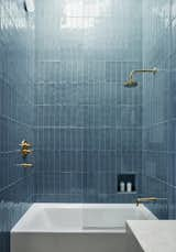 The guest bathroom features bright turquoise Arcilla Field tiles by Ann Sacks and brass fixtures and fittings that will develop a patina over time. A skylight above the shower provides natural light and brightens the room.