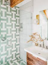 Thomas loves crazy powder rooms, but leans towards softer tones for master bathrooms. Here, she adds a bit of glam with chrome Atrio fixtures by Grohe and antique brass Hinsdale sconces by Hudson Valley Lighting. "I am so happy with how this midcentury-inspired pattern using Fireclay Tile in Daisy and Sea Glass turned out. It’s dramatic, but still soothing and soft. The sconces reminded me of modernist versions of soap bubbles, and I loved them for a bathroom environment."&nbsp;&nbsp;