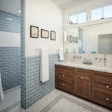 Outfitted in a soothing powder blue color scheme, the primary bathroom continues the home’s focus on standout tile work.