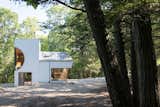 The secluded property designed by architect Steven Holl is only 918 square feet, and is set on a clearing amid towering trees.