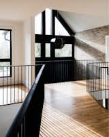 Separate wings off the mezzanine lead to different corners of the home. Andersen’s striking A Series windows with black steel frames were used throughout the residence.