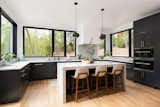 The kitchen's picture windows by Andersen Windows &amp; Doors offer views of the river and surrounding wooded landscape.&nbsp;