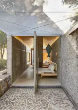 The bedroom door opens to nature on an axis, creating an interesting approach to indoor-outdoor living.