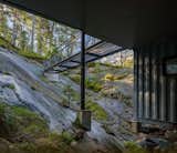 A view of the sky bridge from the lowest level of the home shows how it connects the home to the forest. Tham calls it a "tentacle  Photo 6 of 7 in A Shipping Container Home Rises on a Rocky Site Outside Stockholm