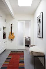 Hallway and Porcelain Tile Floor <span style="font-family: Theinhardt, -apple-system, BlinkMacSystemFont, &quot;Segoe UI&quot;, Roboto, Oxygen-Sans, Ubuntu, Cantarell, &quot;Helvetica Neue&quot;, sans-serif;">"All of the closet doors in the hallway were custom built with matte-black hardware to match the black accents in the kitchen and living room area,  Photo 1 of 5 in Pocket door by Linda Foster from Before & After: “Patience and Perseverance” Save a Rundown Eichler Home With a Major Mold Problem