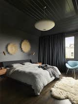 "The dark, moody primary suite and its contrast to the bright and airy primary bathroom shower are another favorite of both the design team and the homeowners,