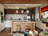 Kitchen, Pendant Lighting, Wood Cabinet, Medium Hardwood Floor, White Cabinet, Cooktops, Wood Counter, and Drop In Sink The kitchen backsplash is from Tiento Spatula, and the island bench is made from Tasmanian oak timber.  Photo 13 of 15 in 15 Modern Kitchen Island Ideas from They Made a New Life in Australia, and Built a Family Home That Merges Past and Present