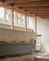 The overhead windows cast light and shadows above the kitchen, which is lined in lower drawers for easy access.