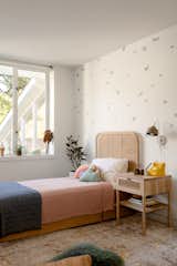Brimer Workshop designed a custom trundle bed for this room, and it's paired with a headboard from The Family Love Tree. The butterfly wallpaper is by Bien Fait.
