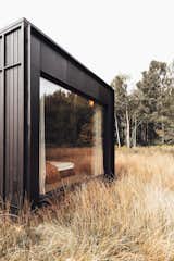 In this model, the client has customized the exterior to be black wood.  Photo 8 of 11 in These Tiny Prefab Cabins Are Designed to Feel Like Luxe Hotel Rooms