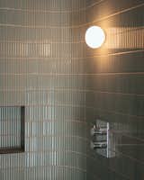 Their bathroom has floor-to-ceiling sage tiles in the shower, coordinating with the green shade used in the kitchen.