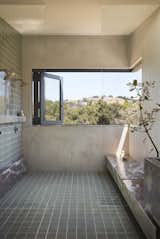 "A matching bench extends into the open shower where accordion corner windows can open entirely,