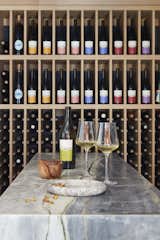 "The space is organized around a central monolithic stone 'altar', with a backdrop of solid oak wine racking,