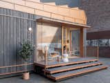 Outdoor, Metal Fences, Wall, Wood Patio, Porch, Deck, Small Patio, Porch, Deck, Shrubs, Metal Patio, Porch, Deck, and Side Yard The simple wood exterior can be customized based on the owner's wishes.  Photo 7 of 9 in Cosmic Buildings’s $279K Tiny Home Recycles Water and Generates Its Own Solar Power