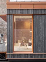 Exterior, Wood Siding Material, Metal Roof Material, and House Building Type A full-length window catches light from the side of the ADU.  Photo 8 of 9 in Cosmic Buildings’s $279K Tiny Home Recycles Water and Generates Its Own Solar Power