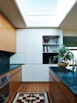 "We contrasted the linearity of the etched granite by curving the island edges and introducing fridge panels with hand-carved pulls,