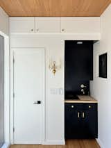 The kitchenette has brass fixtures and top-to-bottom storage.