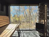 Like the cabin, the sauna features a wall of windows to frame the woods.