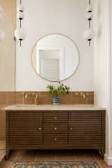 A full vanity sits between the shower and the pocket door to the powder room.
