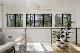 The loft is brightened by a wall of windows that provides views of the surrounding trees.