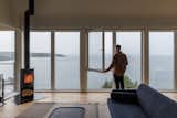 The windows were one of the biggest splurges at about CAD $65,000. “The project boiled down to the view,” says architect Evan Hoyles. A Morsø woodstove anchors the corner of the living space.