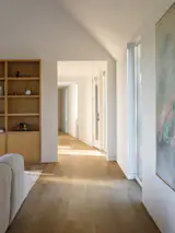 A long hallways separates the common areas from the three bedrooms and bathrooms, and a slight curve provides some privacy.