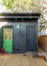 Stanley lays in front of where the water heater is stored, which serves the studio and the primary home. The rain chain is from Nutshell.