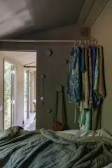 Wall hooks and a clothing rack ensure that things don't clutter the floor.  Photo 7 of 8 in Seven People Can Sleep in This 200-Square-Foot Tiny Home