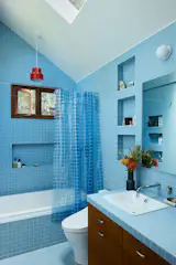 Daltile Keystone tiles in Waterfall were used throughout the expanded bathroom alongside a coordinating shower curtain from Quiet Town.