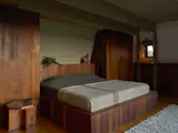 Deena and Austin's primary bedroom puts the focus on the views with a bed that faces it. The bed is on a custom platform and surrounded by cabinetry the couple built.