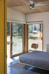 The bedroom opens out onto the deck and meadow beyond.