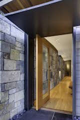 A custom pivoting door emphasizes the continuity of the stone wall.