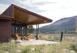 Outdoor, Concrete Patio, Porch, Deck, Side Yard, Grass, Trees, Hardscapes, Field, Shrubs, Large Patio, Porch, Deck, and Boulders  Photo 13 of 13 in Wolf Creek Cabin by Prentiss + Balance + Wickline Architects