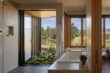 The main bathroom shower opens completely to the outdoors, sheltered by the wood screen.