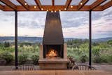The fireplace brings the feeling of a cozy living room to the outdoors, topped only by the natural beauty of the hills beyond.