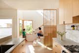Lee Buchanan of Lee Build created a screen of white ash slats beside the kitchen as well as the entry. "The stairs are beautifully integrated into the kitchen so the kids and I are always talking and someone is always sitting on the bottom steps,