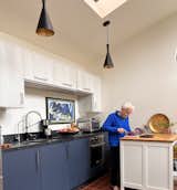 The compact yet fully outfitted kitchen enables Mary to prepare meals and host friends. The pendants are by Livex. The cabinets are standard Ikea boxes with doors by Semihandmade.