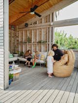 Lizz Wasserman and Isaac Resnikoff relax in the open-air sitting area of their home in Highland Park with their children, Eli and Esphyr. The Omera Hand love seat is from Urban Outfitters.