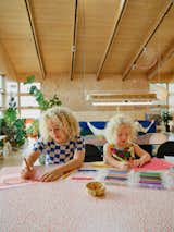 Eli and Esphyr color at a kitchen counter (made of dead stock Bacterio laminate by Ettore Sottsass) that Isaac built.