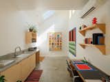 Warwas finished the high-ceilinged ADU kitchen with a skylight and a large square window that fills the space with natural light. The artworks are by Antonio.