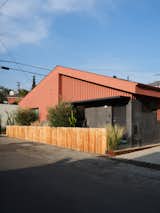 Knight combined Hardie board and wood siding on the exterior of the duplex, which features the ADU at left and a single-family unit at right, unifying them with Benjamin Moore's Burnt Sienna.