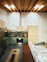 Knight paired affordable leathered granite with green Ikea cabinets in the kitchen, along with European Baltic birch doors on the larger cabinets. Hannah found the modular units behind the sofa on Wayfair. "They come with a cleat system and can be stacked vertically or mounted on a wall as well,