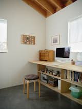 Hannah and Rami converted the second bedroom into an office, featuring a plywood-topped desk and shelving unit that Hannah made for their previous rental.