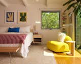 A Nelson bed and bench join a Design By Them love seat in the primary bedroom. The hand-knotted linen rug is by Palermo, and the artworks are by Virginie Hucher.
