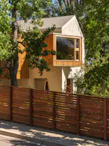 Clad in wood, a window seat cantilevers off the new primary suite and creates a covered patio below it.