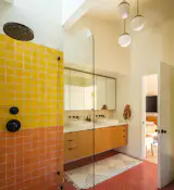 A variety of cement tiles from Zia Tile brightens the new primary bathroom. Constantino Camacho of CJD Builders Inc. custom built the vanity, which Warwas set off the floor to make the room feel bigger.