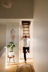 An oak ladder handcrafted by Josiah Johnson leads to a 300-square-foot loft, which is a favorite hangout spot for the couple's sons and their friends. "Because it's one of the first things you see when you come up the stairs and around to the living area, we didn't want some typical attic ladder,