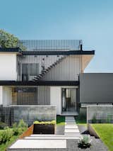 007 House exterior with black slat facade and concrete landscape walls